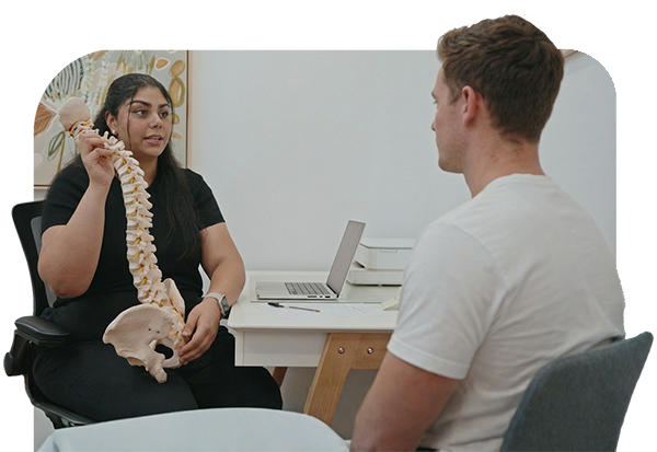 Chiropractic Spine Education Consultation in Canterbury - Radiant Chiropractic Canterbury Chiropractor in Canterbury explaining spinal alignment to a patient during consultation