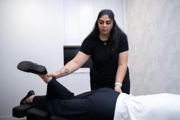 Chiropractor gently lifting and assessing a patient’s leg during a chiropractic treatment session