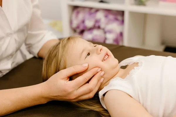 Child receiving gentle chiropractic neck support, representing paediatric chiropractic care at Radiant Chiropractic in Canterbury, Eastern Melbourne.