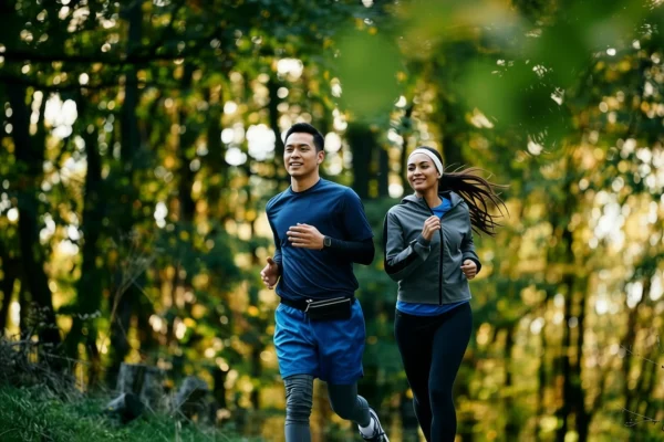 Two adults jogging outdoors in a natural setting to support daily movement, spinal health, and overall wellbeing.