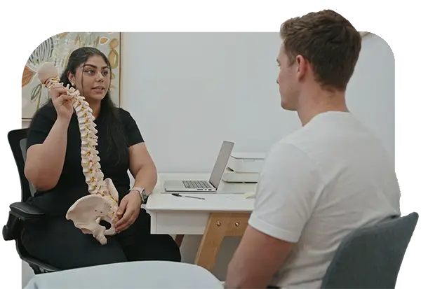 Chiropractor explaining spine alignment and posture to a patient during consultation