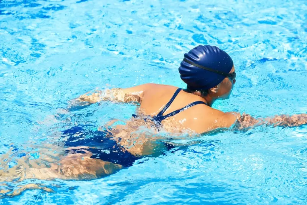 Person swimming in a pool, demonstrating low-impact exercise and full-body movement